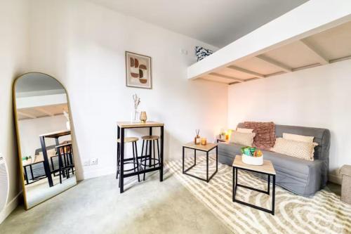 a living room with a couch and a table at Le Petit nid cocooning - Studio chaleureux et élégant in Aubervilliers