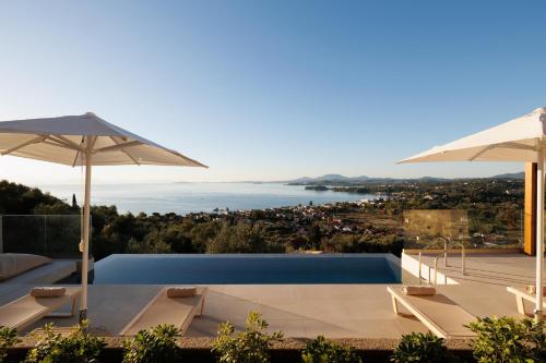 a villa with a swimming pool and umbrellas at Thaleri Villa in Pyrgi