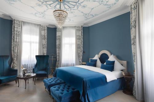 una camera blu con un letto e un lampadario a braccio di Schloßhotel Althörnitz a Hörnitz