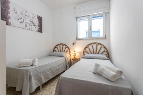 twee bedden in een kamer met witte muren en ramen bij Apt Grecale e Ponente vista mare - Salento Reservation in Isola della Malva