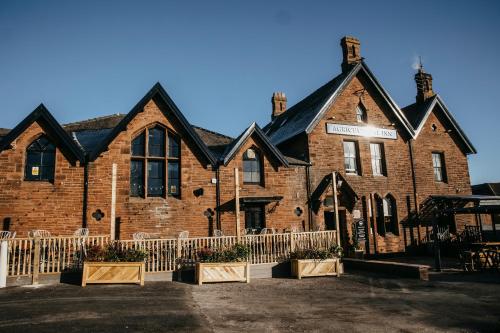 a large brick building with a fence in front of it at Agricultural Inn in Penrith
