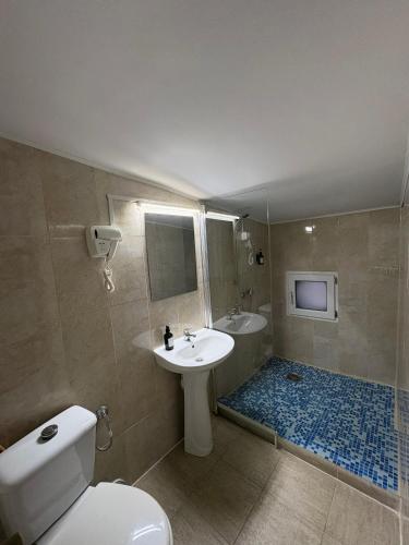 a bathroom with a white toilet and a sink at Vila Ada in Bucharest