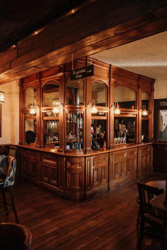 a large wooden bar in a room with wooden floors at Agricultural Inn in Penrith
