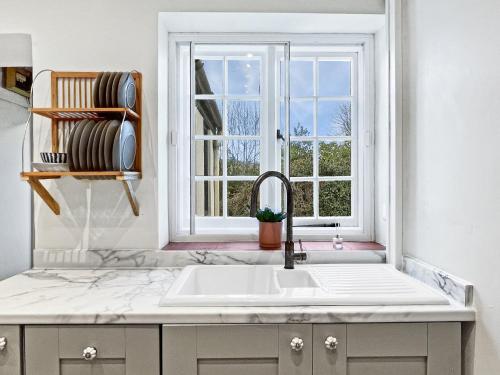 a kitchen with a sink and a window at Bossington Green Cottage in Porlock