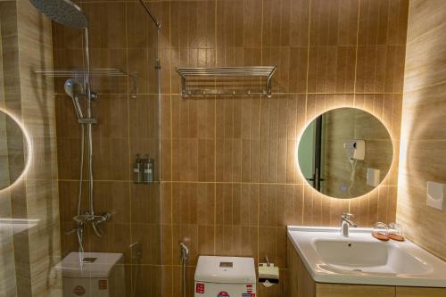 ein Badezimmer mit Waschbecken, Toilette und Spiegel in der Unterkunft Cham Charm Apartment Hotel Mui Ne in Mui Ne