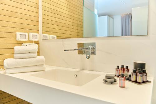 um banheiro com pia branca e espelho em H7 TLV em Tel Aviv