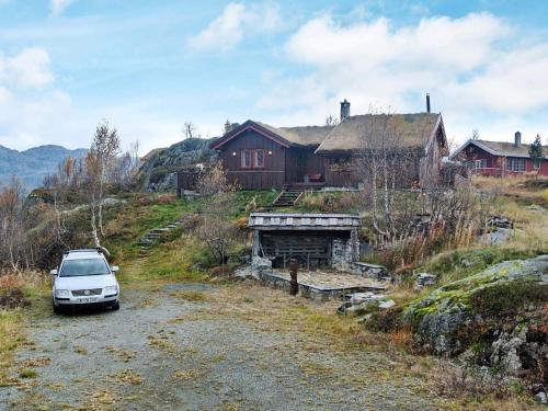 ein Auto, das auf einer unbefestigten Straße vor einem Haus parkt in der Unterkunft 11 person holiday home in Edland in Vågsli
