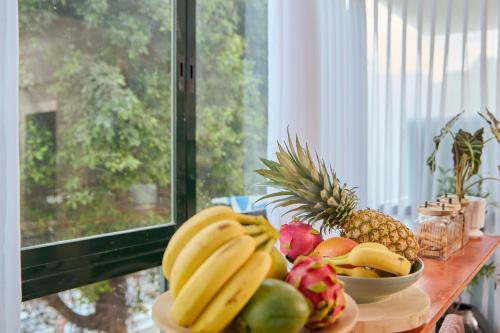 un tavolo sormontato da ciotole di frutta sopra una finestra di H7 TLV a Tel Aviv