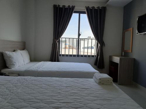 ein Hotelzimmer mit zwei Betten und einem Fenster in der Unterkunft SAY HOTELO, Nha Trang in Nha Trang