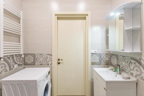 a white laundry room with a washer and dryer at The Urban Retreat in Tbilisi City