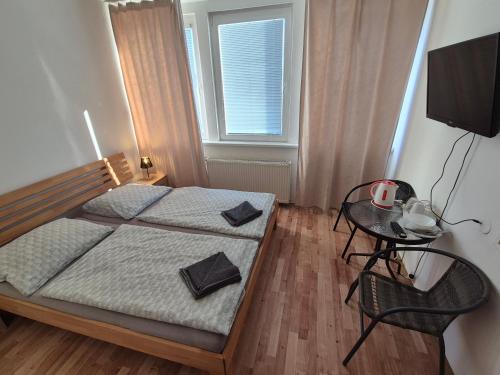 a bedroom with a bed and a table and a window at Penzión Tina in Prešov