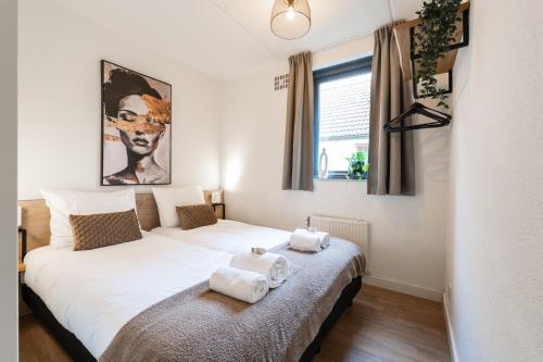 ein Schlafzimmer mit zwei Betten mit Handtüchern darauf in der Unterkunft Newly Refreshed Family-stay For 7 By The Lake in Ewijk