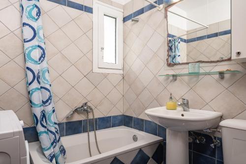 une salle de bains avec lavabo, baignoire et toilettes dans l'établissement Nostos - Psili Ammos Appartments, à Psili Ammos