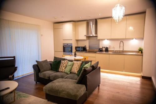ein Wohnzimmer mit Couch und Küche in der Unterkunft Stylish Kent apartment in Maidstone