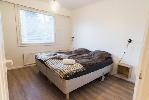 ein Bett in einem Zimmer mit Fenster in der Unterkunft Renovated 60m2 flat & free parking, balcony, Wifi in Pori