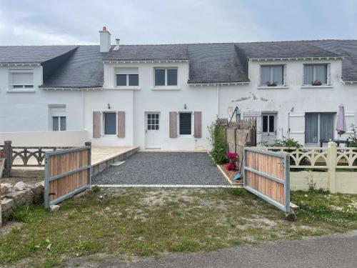 ein weißes Haus mit einem Zaun und einer Einfahrt in der Unterkunft Maison proche bourg et plage in Piriac-sur-Mer