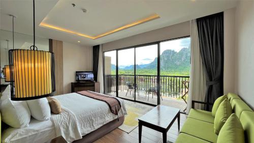 a bedroom with a bed and a view of a balcony at Amari Vang Vieng in Vang Vieng
