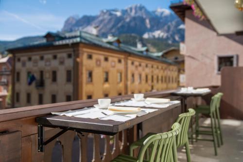 Una mesa y sillas en un balcón con vista. en Hotel Montana, en Cortina dʼAmpezzo