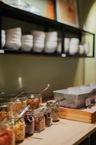 默恩达尔Best Western Plus Åby Hotel的柜台上摆放着装满食物的罐子和架子上的盘子