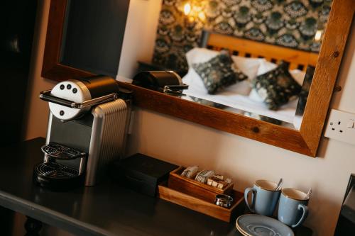 a counter top with a hair dryer and a mirror at Agricultural Inn in Penrith