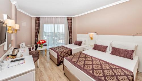 a hotel room with two beds and a television at Serenis Hotel in Side