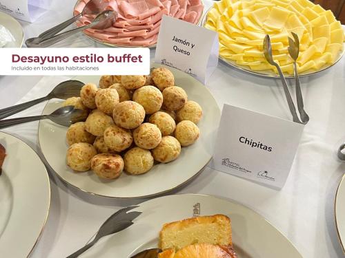 una mesa cubierta con platos de comida y postres en Hotel Cabañas Del Parque, en Oberá