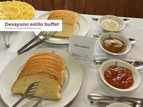 una mesa con dos platos de pan y salsa en Hotel Cabañas Del Parque, en Oberá