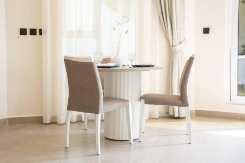 mesa de comedor con 2 sillas y mesa con jarrón en Dana Beach Resort, en Al Sharqiyah