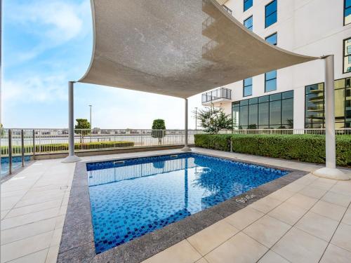 a swimming pool in front of a building at Elite Nest - Chic Studio, 1 min to Ferrari World & SeaWorld in Abu Dhabi