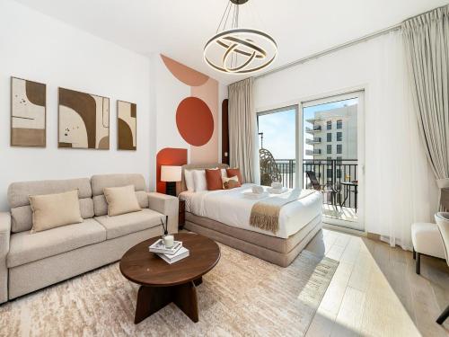 a living room with a bed and a couch at Elite Nest - Chic Studio, 1 min to Ferrari World & SeaWorld in Abu Dhabi