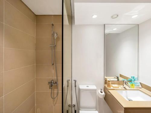 a bathroom with a shower and a toilet and a sink at Elite Nest - Chic Studio, 1 min to Ferrari World & SeaWorld in Abu Dhabi
