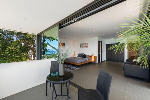 a living room with a bed and a table at Villa Veha, SPA, Fitness and Games room in Amphoe Koh Samui