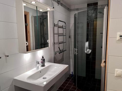 a white bathroom with a sink and a shower at Apartments Klövsjöfjäll in Klövsjö