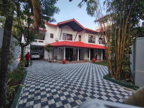 a house with a cobblestone driveway in front of it at Royal Villa Polhena in Matara