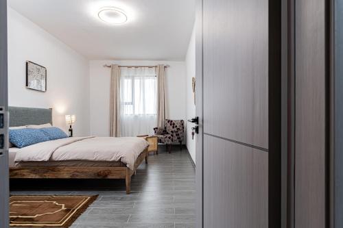 ein Schlafzimmer mit einem Bett und einer Tür, die in ein Zimmer führt in der Unterkunft Diamond Ivy Two Bedroom Apartment, Swimming pool, gym, workspace ,Wonderiss Homes Kileleshwa Living in Nairobi