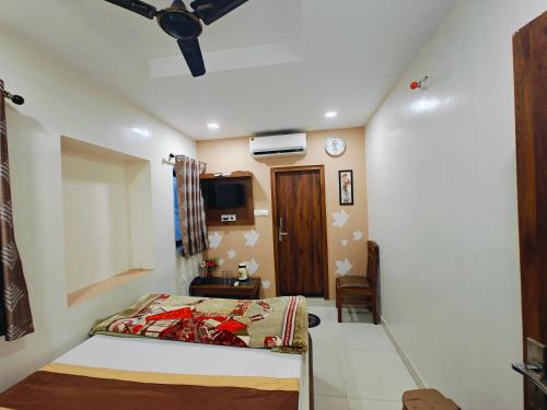 une chambre avec un lit et une télévision dans l'établissement CN Comforts Hotel & Dormitory, à Lucknow