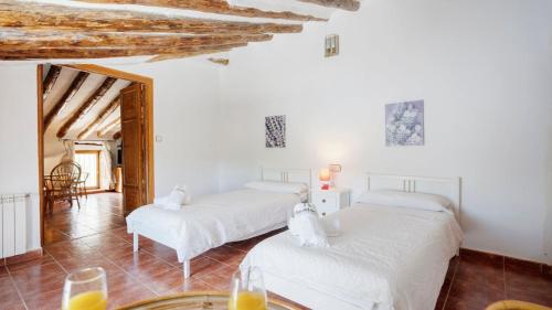 two beds in a room with white walls at Cortijo El Álamo 1 Vélez Blanco by Ruralidays in Vélez Blanco
