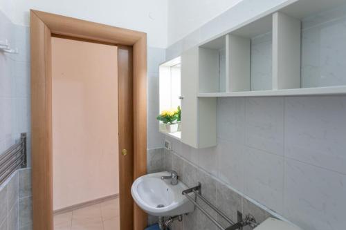 een badkamer met een wastafel, een toilet en een spiegel bij Apt Grecale e Ponente vista mare - Salento Reservation in Isola della Malva