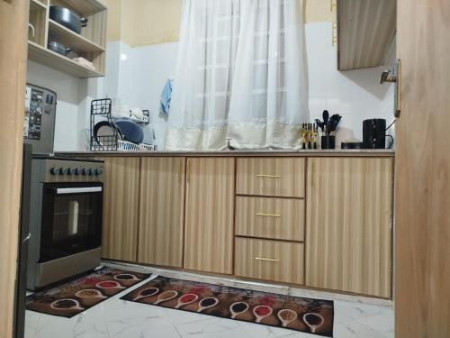 Taste of Home by Chel في ناكورو: مطبخ مع كونتر مع الكعك على الأرض