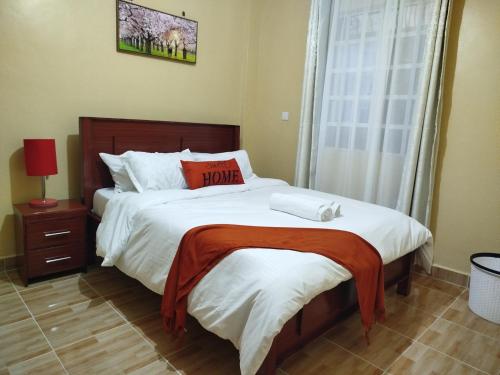 Taste of Home by Chel في ناكورو: غرفة نوم بسرير كبير ونافذة