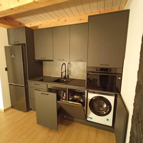 a kitchen with a washer and a sink and a refrigerator at Miejscówka Werlas in Werlas