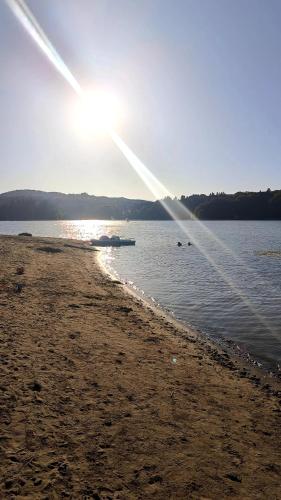 a beach with the sun shining on the water at Miejscówka Werlas in Werlas