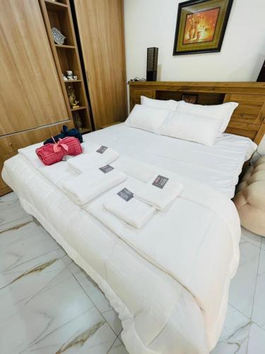 Cozy Private Studio with Garden Al Manhal, Abu Dhabi-5 في أبوظبي: سرير أبيض كبير مع بطاقات فوقه