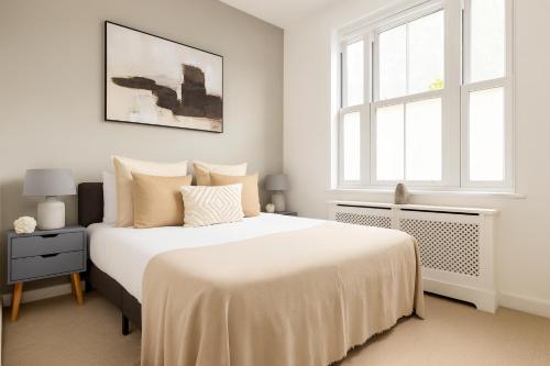 a white bedroom with a bed and a window at Superb 2 Bed Apartment in Battersea in London