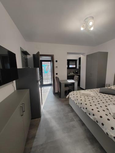 a bedroom with a bed and a kitchen with a table at Râului 43 in Ocna-Mureşului