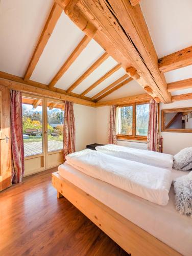 2 camas en una habitación con techos y ventanas de madera en Appt de charme dans chalet - liberté & nature, en Chesières
