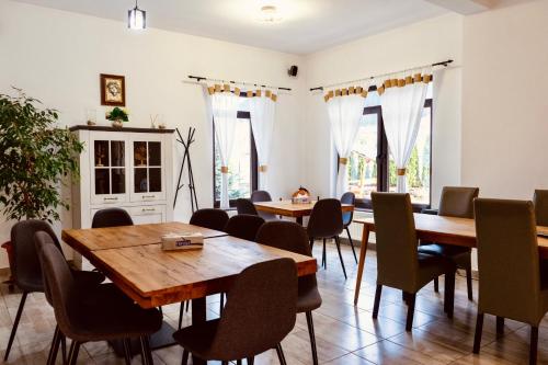 ein Esszimmer mit Holztischen und Stühlen in der Unterkunft Pensiunea Ioana in Sadová