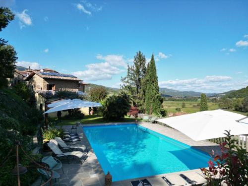 een zwembad in een villa met bergen op de achtergrond bij Agriturismo L'Essiccatoio in Lisciano Niccone