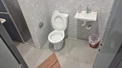 ein kleines Badezimmer mit Toilette und Waschbecken in der Unterkunft Pequeno quarto no coração de Curitiba in Curitiba