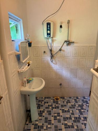 a bathroom with a white sink and a shower at Backpacker Galle Hostel in Galle